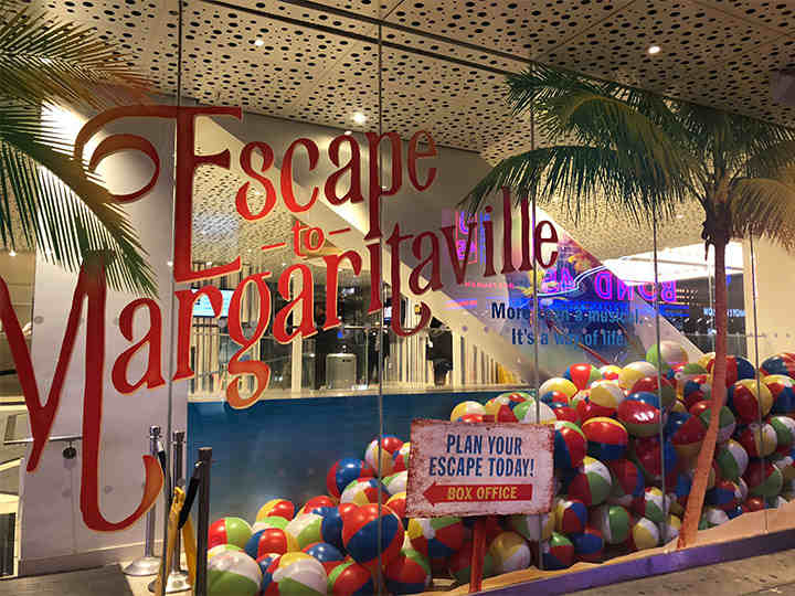 Ticket booth of the Marquis Theatre decorated with palm trees and beach balls
