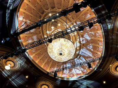 A large chandelier and numerous speakers lighting the theater