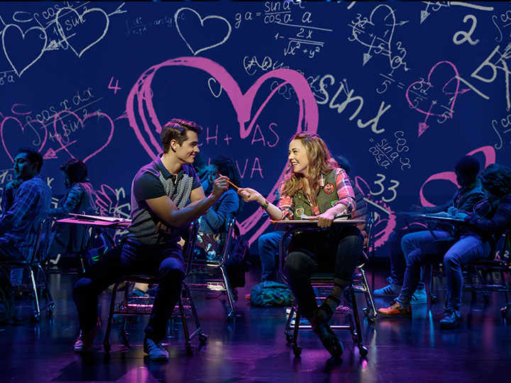 A big heart glows behind the cast