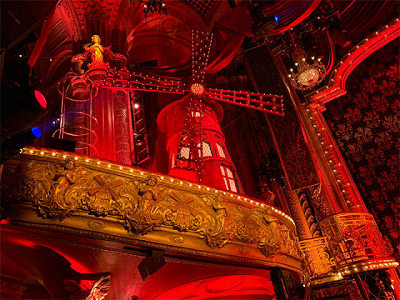 The windmill mounted above stage left is the emblem of Moulin Rouge