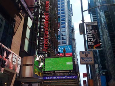 The vertical marquee of Todd Haimes Theatre (formerly American Airlines Theatre) peeking through Times Square signage
