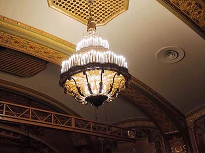 A chandelier set against golden-beige terracotta
