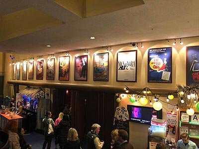 Posters of past productions decorate the theater entrance, where drinks and merchandise are also available