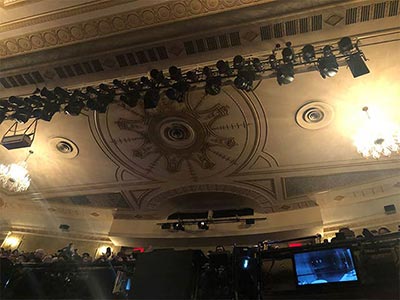Ceiling above the stage decorated with four chandeliers
